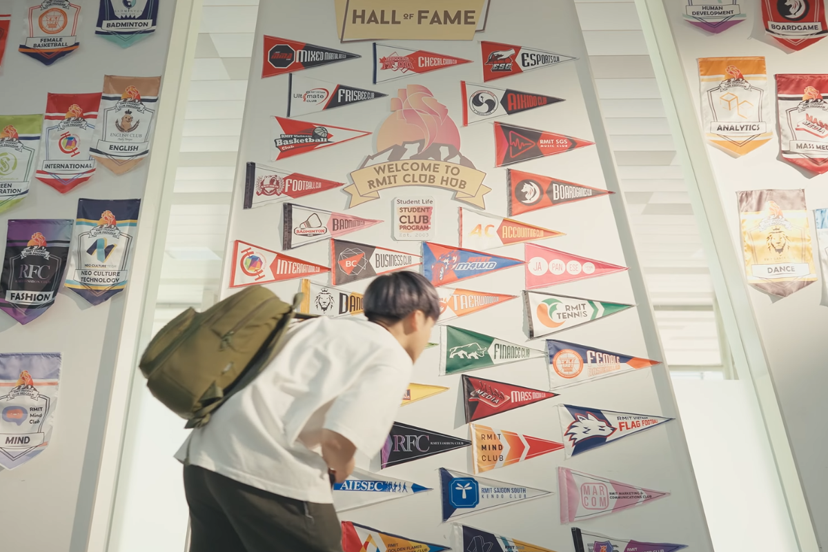 student-standing-before-club-pennants